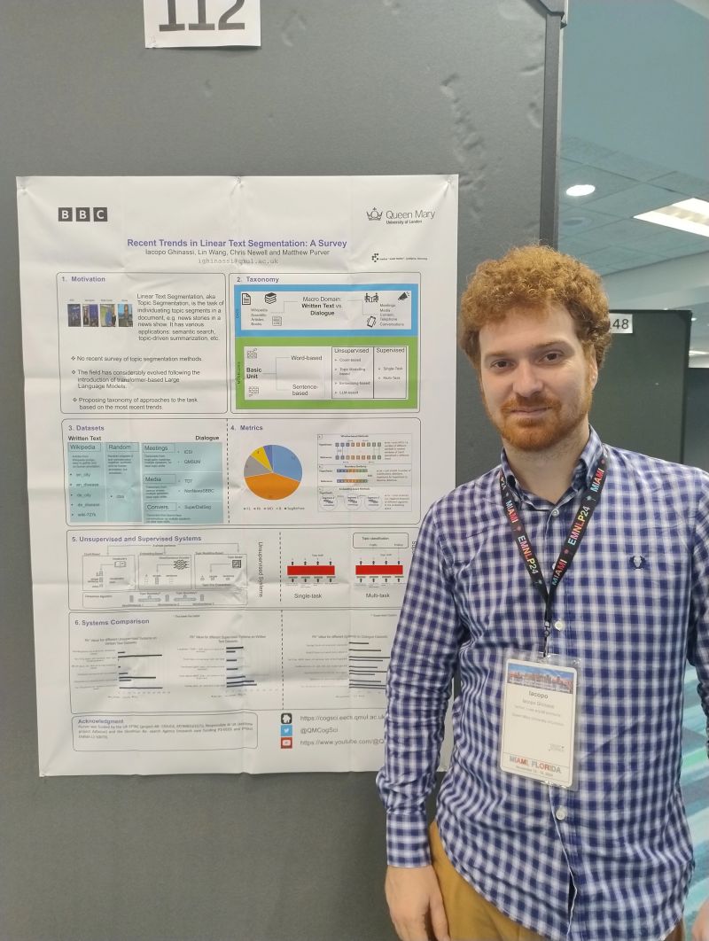 Iacopo Ghinassi standing beside a research poster at a conference.